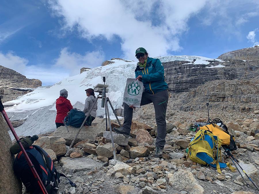 Dr. Nina Adanin, an assistant professor of recreation, displays a Bearcat flag while conducting research of disappearing tropical glaciers in Colombia and Uganda. (Submitted photo) 